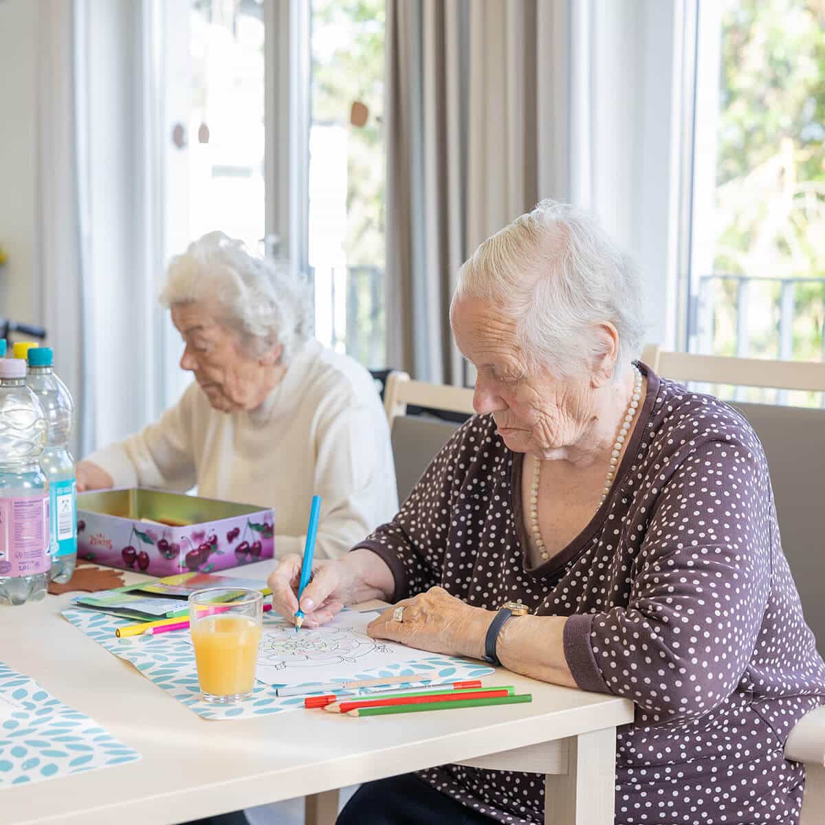 Zwei Seniorinnen malen Mandalas aus