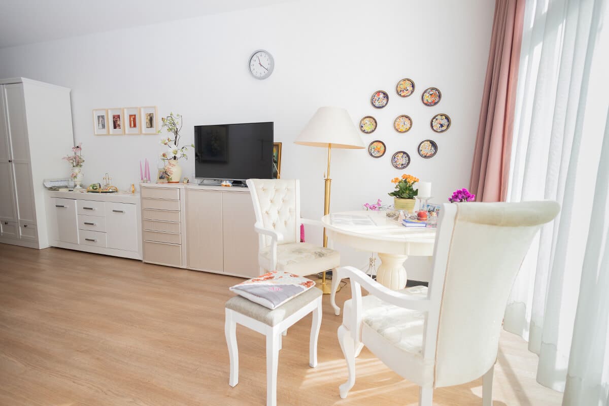 Helles Zimmer mit Tisch und Stühlen und liebevoller Dekoration