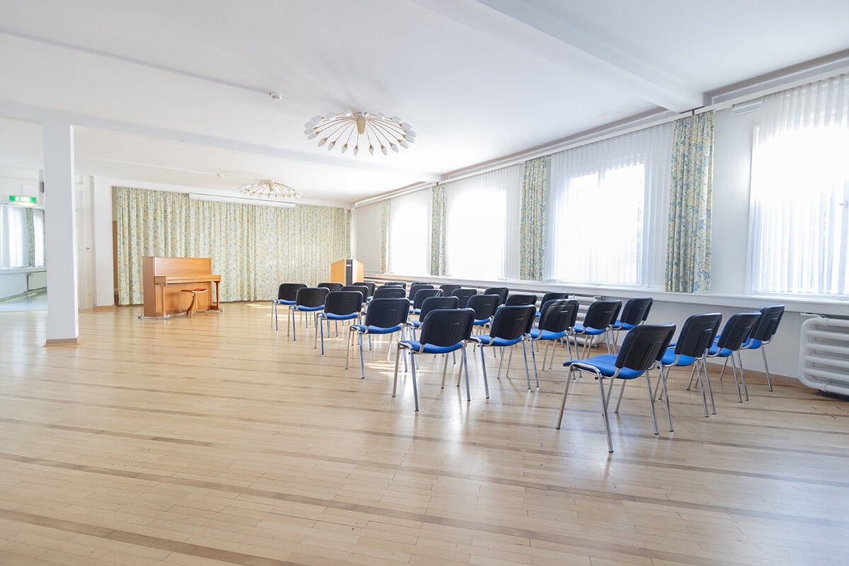Saal für Veranstaltungen mit vielen Sitzmöglichkeiten und Klavier